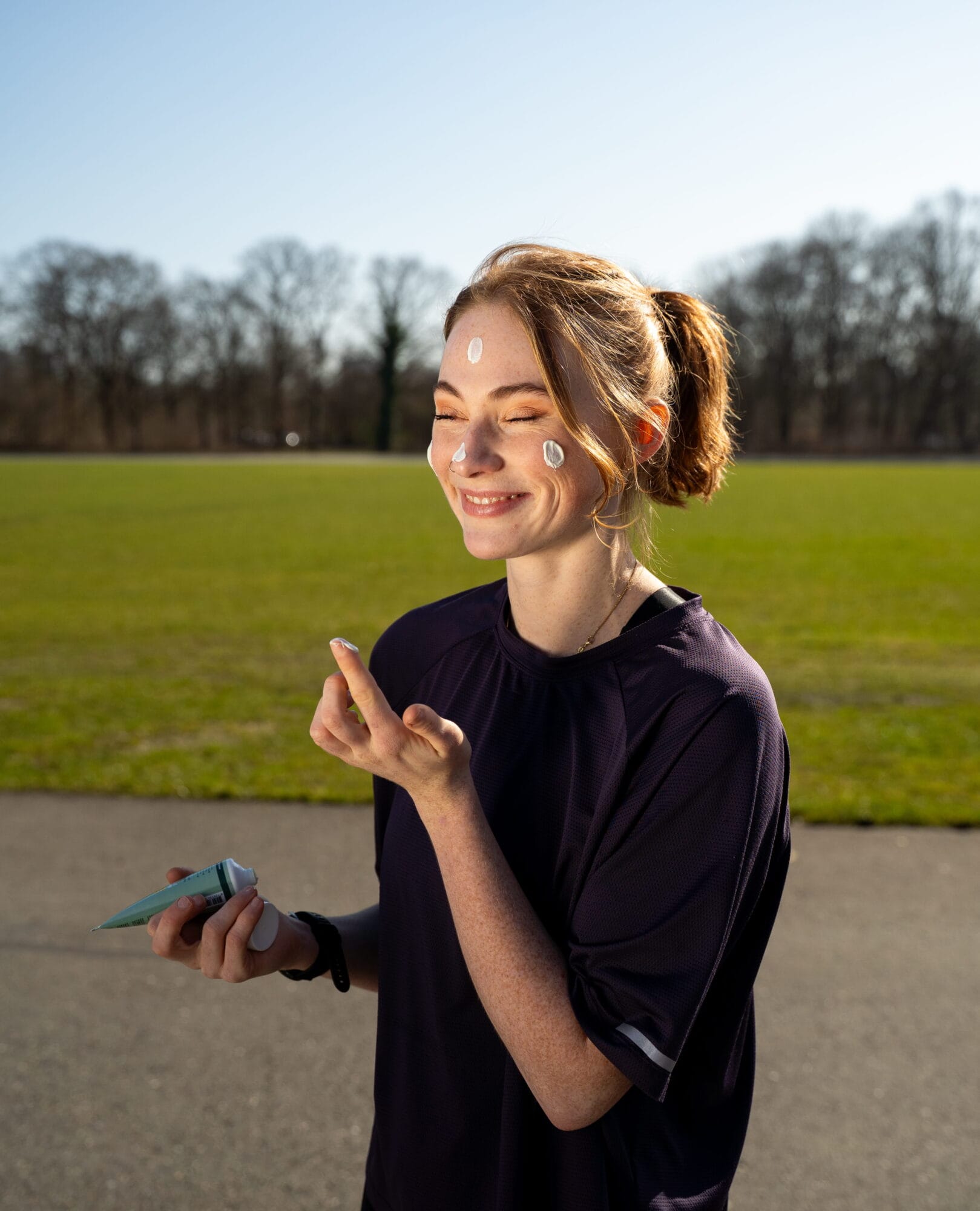 Hardloper gebruikt zweetbestendige zonnebrand SPF 30 die niet in de ogen prikt en snel intrekt voor optimale zonbescherming tijdens het sporten.